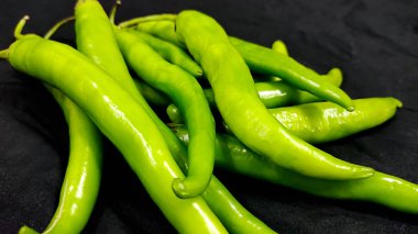 Hindistan 'da siyah arka planda taze yeşil biber.