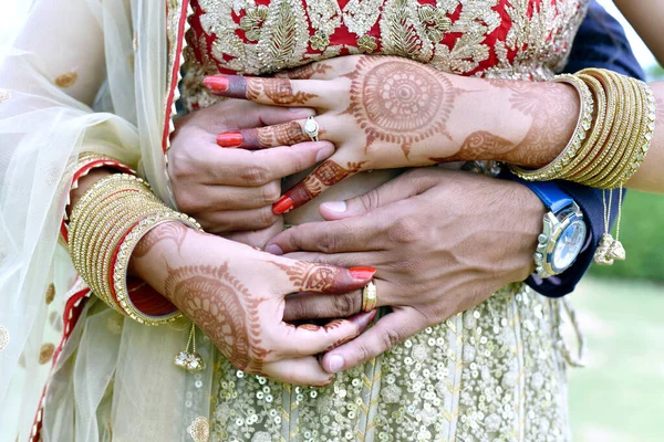 A closup shot of a young couple hugging and showing their wedding rings in india