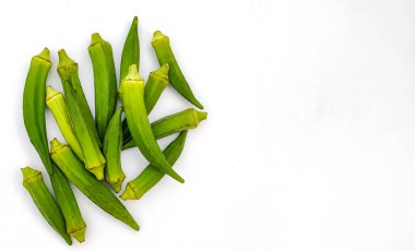 Beyaz arkaplanda çiğ bamya ya ya da kadın parmağı var.
