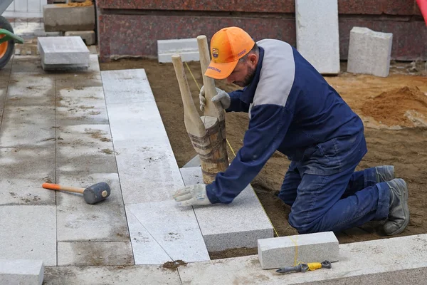 MOSCÚ, RUSIA - 15 DE MAYO DE 2016: El trabajo pone las grandes losas en la acera. Reconstrucción de la carretera dentro del programa de embellecimiento de la ciudad My Street in Moscow . —  Fotos de Stock