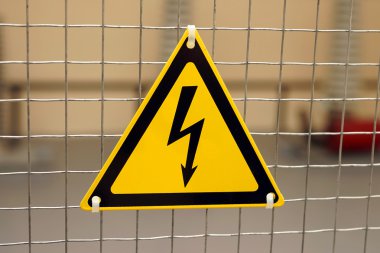 Yıldırım üzerinde sarı bir üçgen şeklinde elektrik tehlike işareti.
