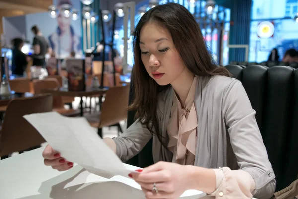 Beautiful Asian girl reading a letter — Stock Photo, Image