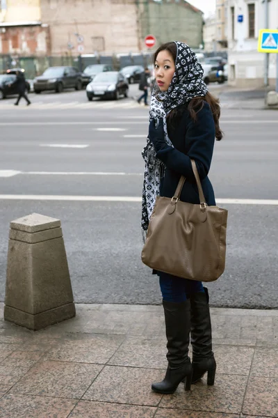 Asiática chica con una bolsa de pie en la acera — Foto de Stock