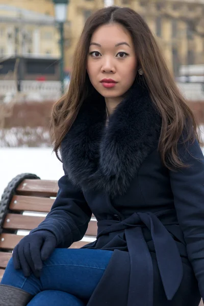 Serious Asian girl in blue coat looks right — Stock Photo, Image