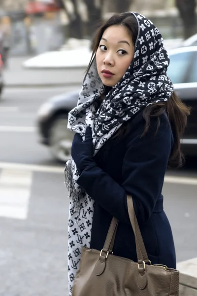 Девушка с сумкой и шарфом на улице, глядя в спину — стоковое фото