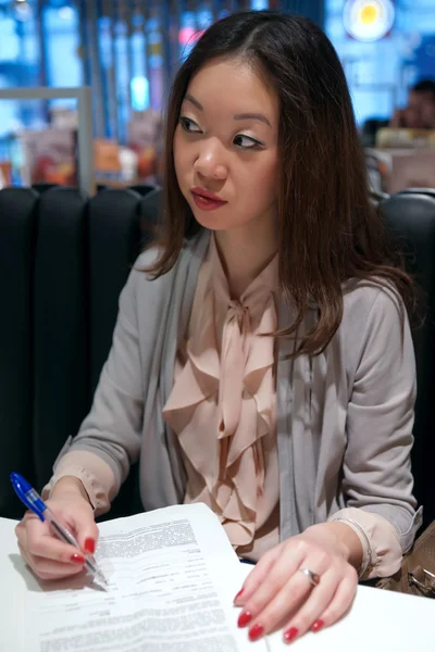 Asian girl writing at the table — Stock Photo, Image