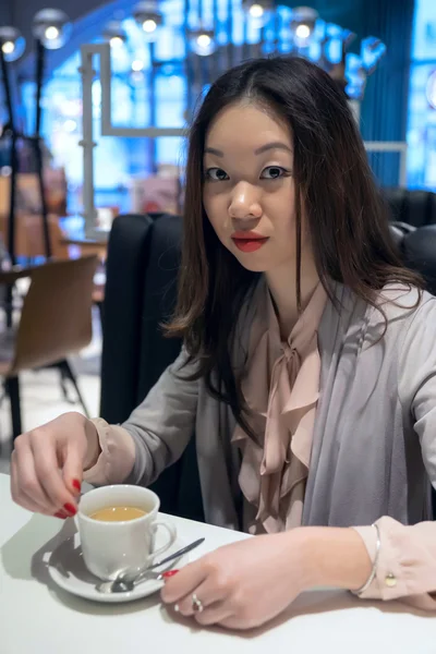 Serious Asian girl drinks coffee. — Stock Photo, Image