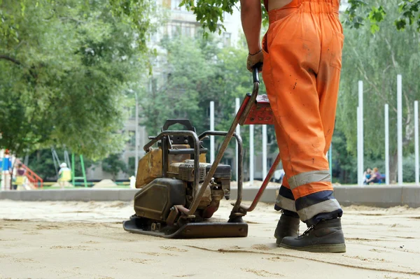 Plaat compactor bereidt zandstrand oppervlak. — Stockfoto