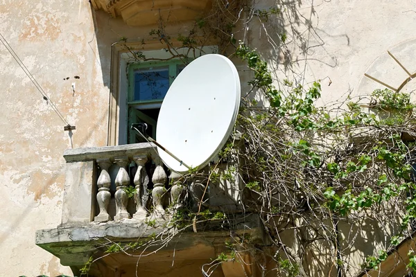 TV satellite dish on the balcony of an old house. — Stock Photo, Image