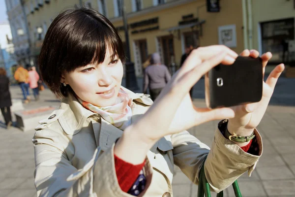 Jong meisje gefotografeerd op een smartphone — Stockfoto