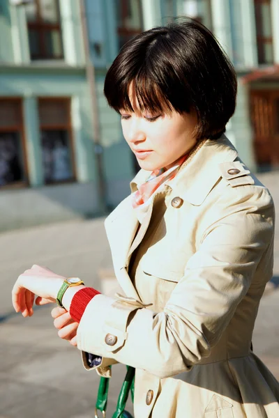 Flickan ser ut på tiden på ett armbandsur. — Stockfoto