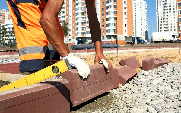 Arbetaren sätter trottoaren trottoarkanten. — Stockfoto