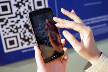 Kız Qr kodu mobil akıllı telefon ile tarar.