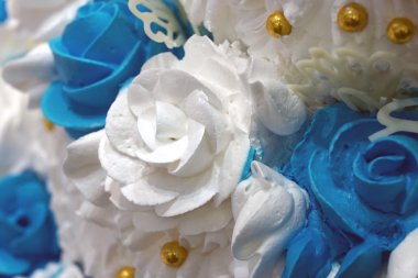 Beyaz krem bir düğün pastası yükseldi.