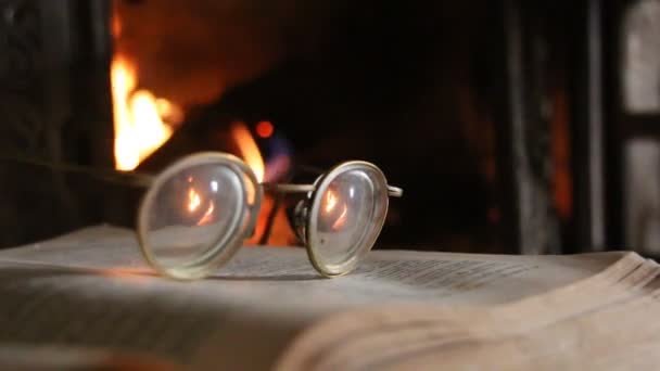 Retro-Brille, offenes Buch und Kamin — Stockvideo