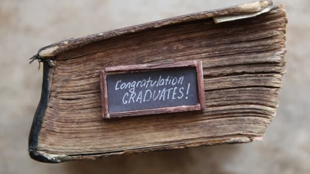 Congratulations graduates text and vintage book on table — Stock Video