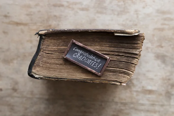 Вітання випускників тексту та старовинної книги — стокове фото