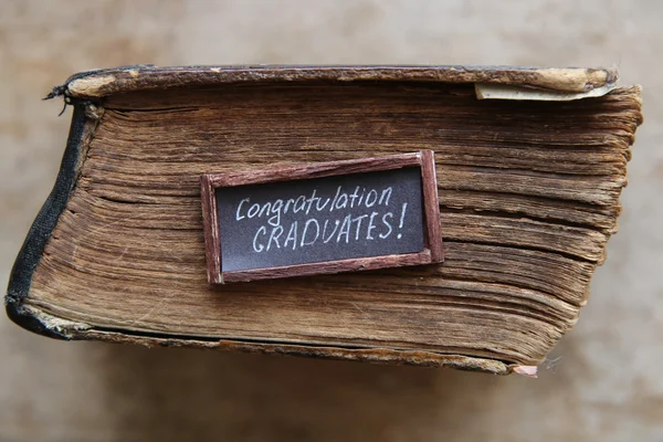 Selamat lulus teks dan buku antik di atas meja — Stok Foto
