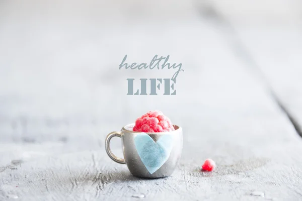 Healthy life idea - text, raspberry and cup with a heart — Stock Photo, Image