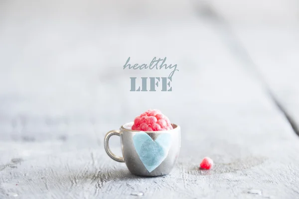 Healthy life idea, raspberry and cup with a heart — Stock Photo, Image