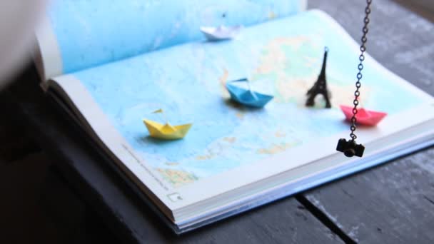 Viaje a la idea del mundo o turismo. Barcos de papel en el mapa y la Torre Eiffel . — Vídeos de Stock