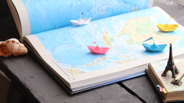 Podróż do świata idei lub turystyki. Papierowe łódki na mapie i Wieża Eiffla. — Wideo stockowe