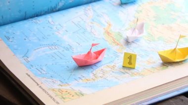 kazanan spor veya iş liderlik fikri, harita üzerinde kağıt tekneler