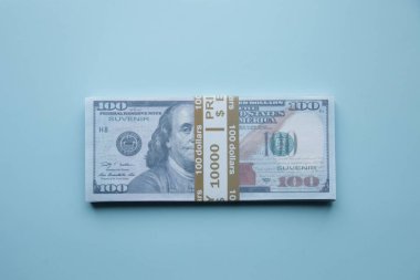 Mavi bir masanın üzerinde bir tomar dolar. Mali konsept.