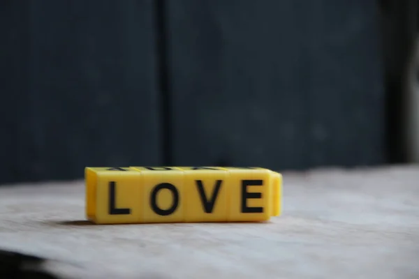 Het Woord Liefde Gemaakt Van Gele Letters Een Houten Ondergrond — Stockfoto