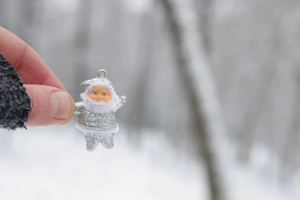 Hand Håller Santa Claus Bakgrunden Vinterskogen — Stockfoto