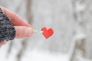 Sevgililer günün kutlu olsun. Elinde kağıt bir kalp var..