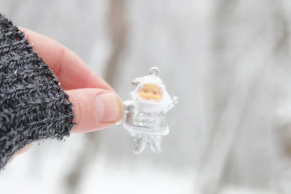 Hand Håller Santa Claus Bakgrunden Vinterskogen — Stockfoto