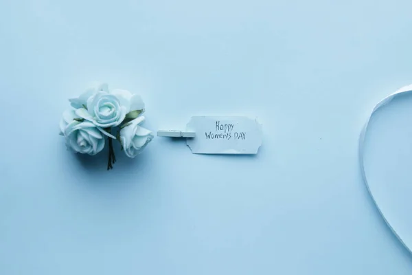 Happy Womens Day. The inscription on a blue label and flowers. — Stock Photo, Image