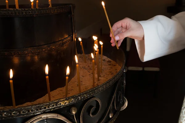 Femme main éclairage bougies dans une église — Photo