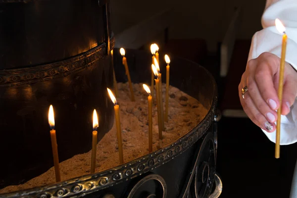 Vrouw Hand Lichtende Kaarsen in een Kerk — Stockfoto