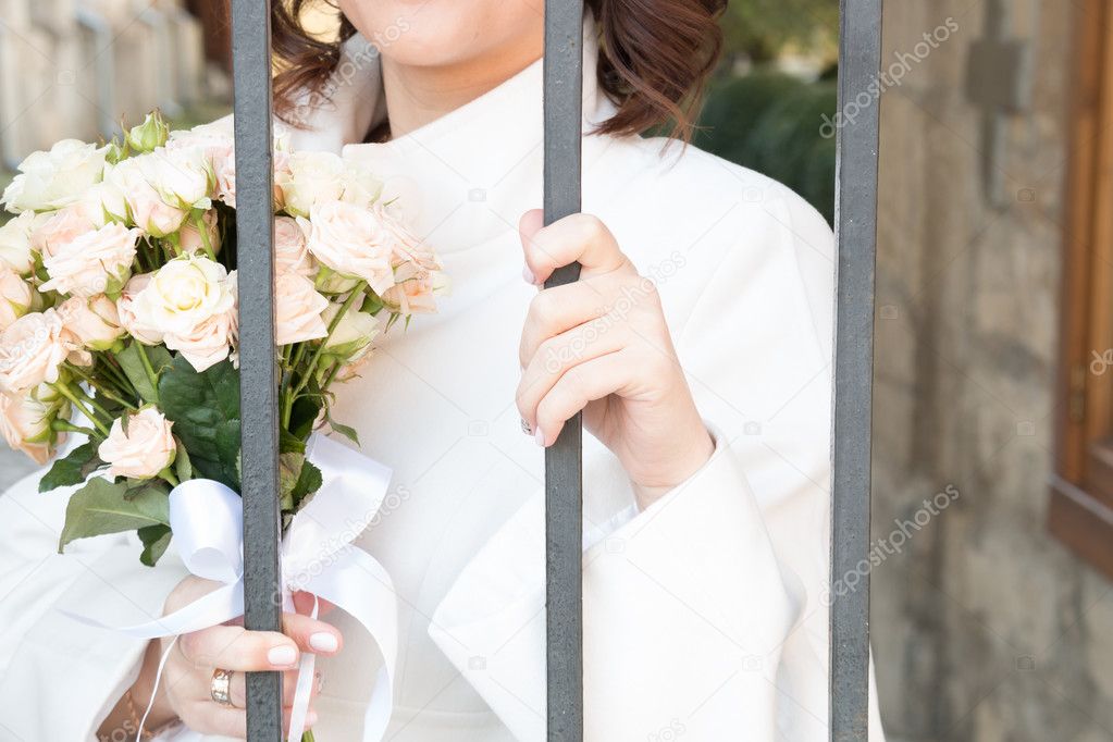 bride with flowers behind bars