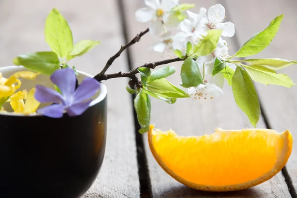 Leaves and orange slice on wooden table — Stock Photo, Image