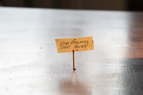 Hand writing on the label "Stop dreaming start doing". — Stock Photo, Image