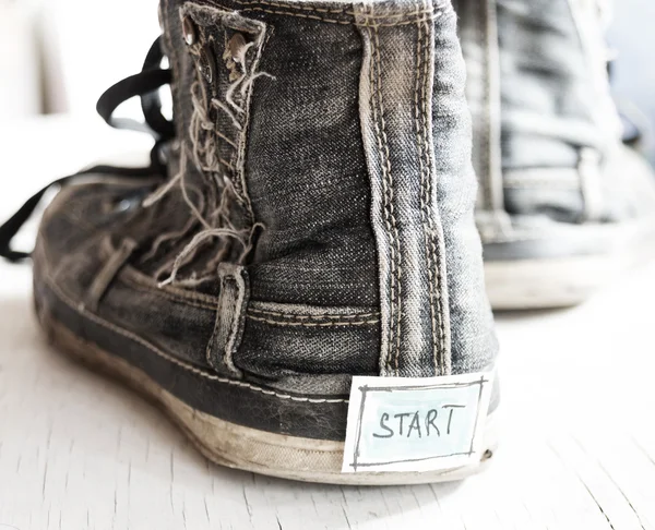 Etiqueta con la palabra inicio en las zapatillas de deporte . —  Fotos de Stock