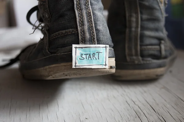 Etiqueta con la palabra inicio en las zapatillas de deporte . —  Fotos de Stock