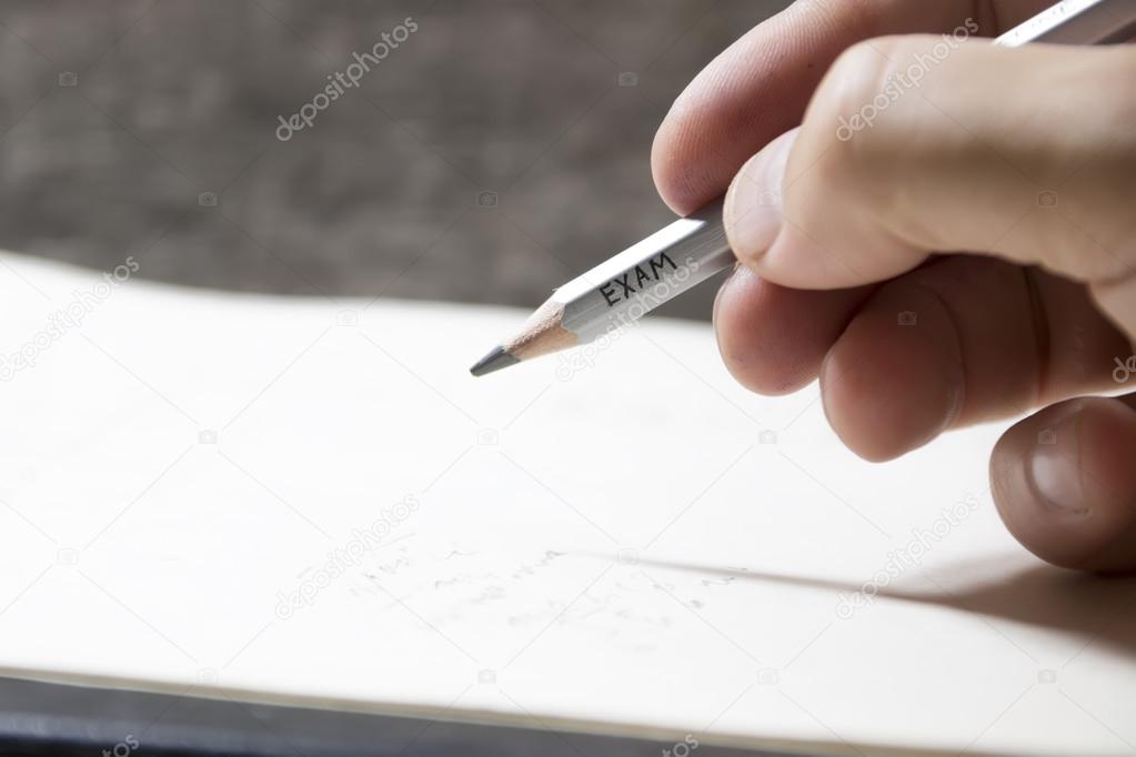 Student writing a test, an inscription on pencil 