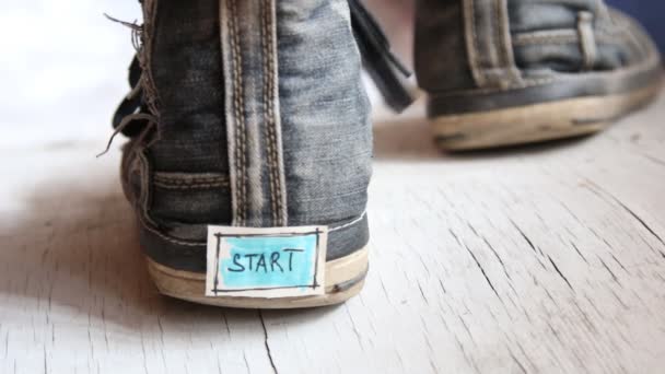 Etiqueta con la palabra inicio en las zapatillas de deporte . — Vídeo de stock