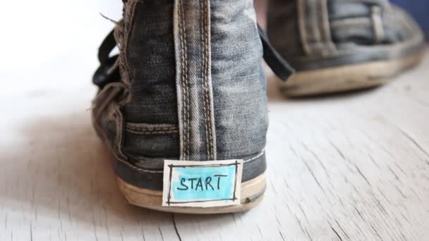 Etiqueta con la palabra inicio en las zapatillas de deporte . — Vídeo de stock