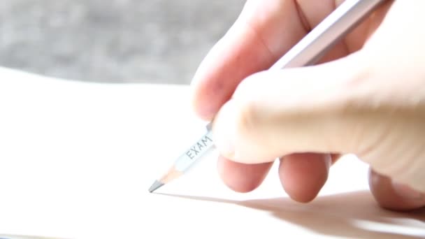 Student skriver ett test, en inskription på penna "examen" — Stockvideo