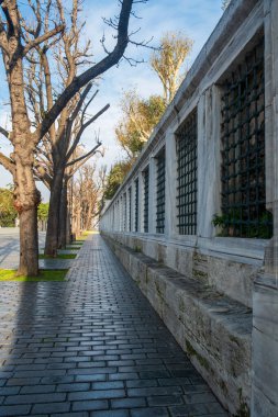 Sultanahmet Meydanı İstanbul 'da, Türk mimarisi detaylarıyla süslenmiş demirden camlar ve taş patikalarla kaplı tarihi cami duvarı.