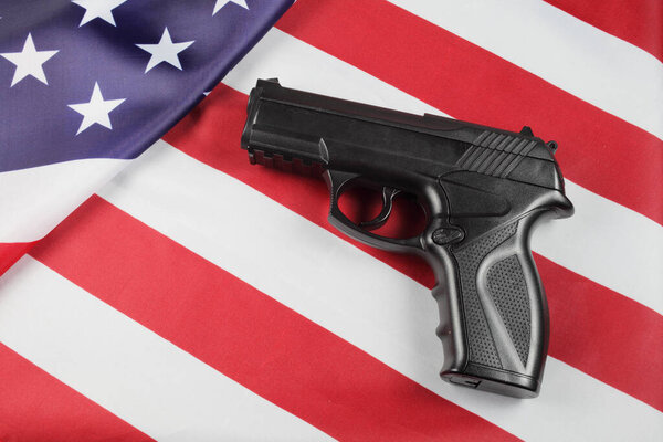 Pistol on the usa flag, close-up, top view.