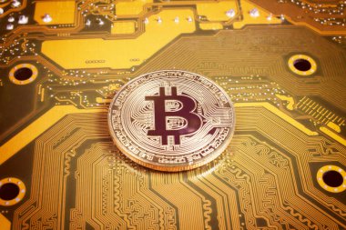 Bilgisayar devre kartındaki altın bitcoin, yakın plan, turuncu tonlama 