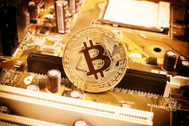Bir bilgisayar anakartındaki altın bitcoin, yakın plan, renkli turuncu, üst görünüm 