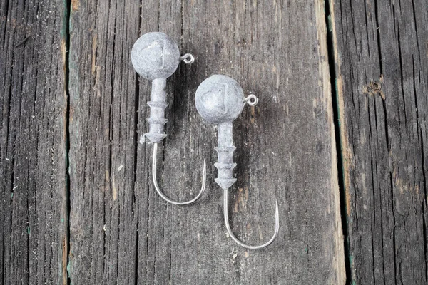 Karanlık bir arka planda batmış iki olta iğnesi. 