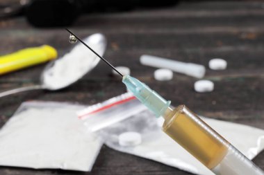 Arka planda bulanık bir şırıngada eroin, bokeh, yakın plan. 